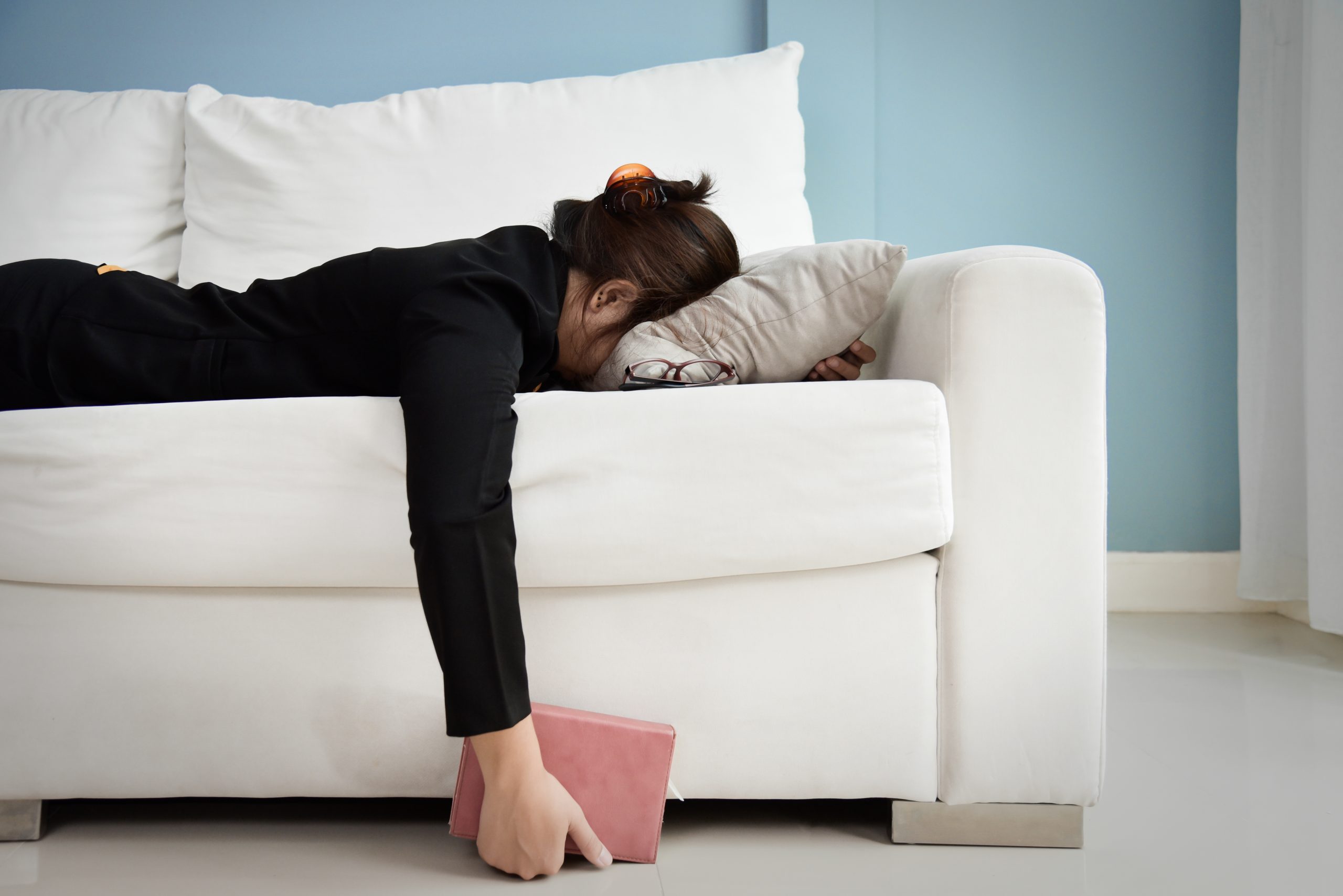 Business woman collapse face-down on couch