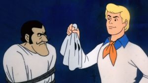 Scooby Doo villain reveal. Fred lifting mask off bad guy