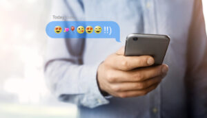 Person texting with emojis