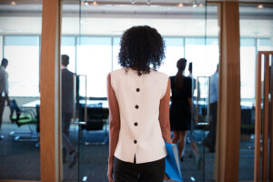 Back view of a woman walking out of a meeting