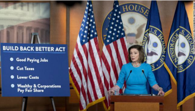 Nancy Pelosi standing behind a board with bullet points